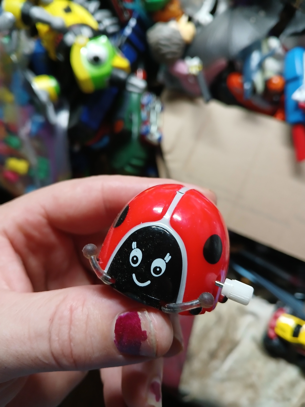red plastic toy is a Lady Bug Rollover Wind Up by Tin Toy Arcade,